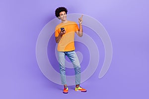 Full size cadre of chevelure guy wear t shirt indicating finger empty space shutterstock phone app isolated on violet