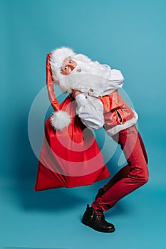 Full size of Cheerful Santa Clause who raises big huge sack with toys isolated over color background