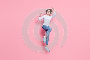 Full size photo of cheerful girl win jump raise fists wear pullover gumshoes isolated pink color background