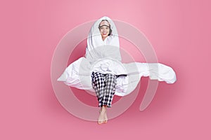 Full size photo of cheerful lady late morning sit bed hold around head warm blanket look empty space wear mask white