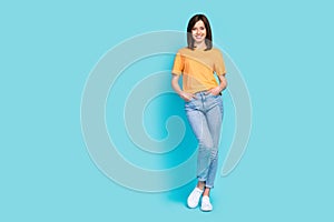 Full size photo of confident friendly girl toothy smile put hands pockets  on blue color background