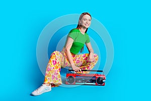 Full size photo of cool adorable girl wear stylish top print pants sit with retro boom box at party isolated on blue