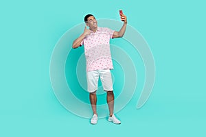 Full size photo of cool guy dressed casual polo white shorts make selfie on smartphone show thumb up isolated on teal