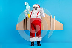 Full size photo of crazy white grey hair bearded santa claus have craft wings win water gun game raise fist x-mas