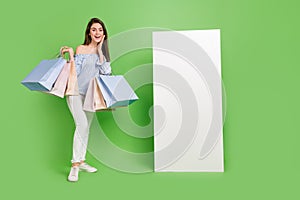Full size photo of cute charming lady impressed to see promotion banner isolated on green color background
