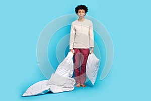 Full size photo of cute young guy hold blanket pillow frightened open mouth dressed white pajama outfit isolated on blue