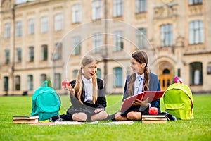 Full size photo of excited kids with brunette blonde pigtails ponytails look at note books have rucksacks backpack sit