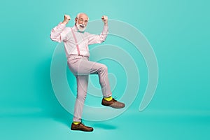 Full size photo of funny excited grandpa raise fists leg celebrate senior meeting party wear specs pink shirt suspenders