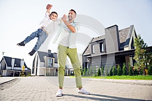 Full size photo of happy positive smiling cheerful family father and little son playing having fun outside outdoors