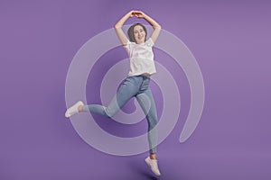 Full size photo of joyful carefree girl jump air fly hands up elegant ballerina isolated on violet color background