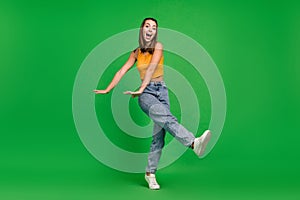 Full size photo of millennial funky brunette lady dance wear top jeans shoes isolated on green color background