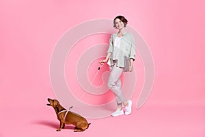 Full size photo of nice bob hairdo lady hold laptop with dog wear grey green suit isolated on pink background