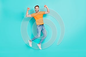 Full size photo of optimistic satisfied man muscular beard wear orange t-shirt jeans flying directing at himself