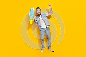 Full size photo of overjoyed satisfied person hold water gun raise fist isolated on yellow color background