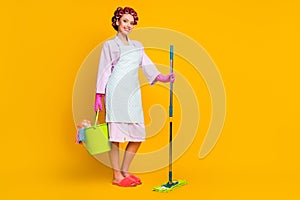 Full size photo of positive girl hold bucket mop wear bath robe gloves slippers isolated bright color background