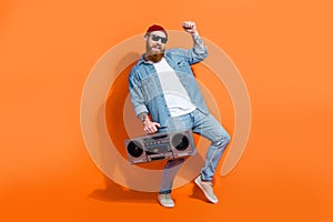 Full size photo of positive young guy holding boom box raise fists win music event isolated on bright color background