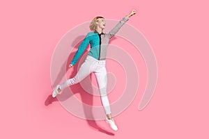 Full size photo of pretty young girl flying superhero wear trendy striped cyan outfit isolated on pink color background