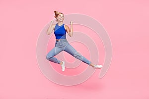 Full size photo of pretty young woman jump fight empty space wear blue top isolated on pink color background