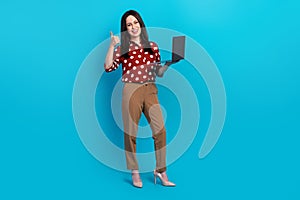 Full size photo of satisfied person wear red blouse brown trousers recommend buy laptop show thumb up isolated on blue