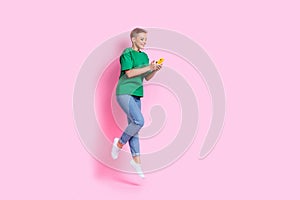 Full size photo of smart girl dressed green t-shirt fly look at impressive internet speed on smartphone isolated on pink