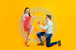 Full size photo two people geek man propose give ring crazy delighted woman raise fists wear red dotted dress legs mini