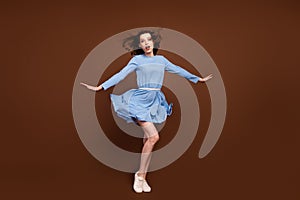 Full size photo of young attractive girl wind blow air hold arms isolated over brown color background