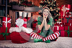 Full size photo of young cheerful woman santa claus helper hands face bag sack present indoors inside house home