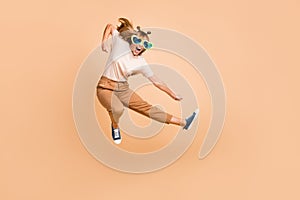 Full size photo of young crazy girl jump up battle fight ninja isolated over beige color background