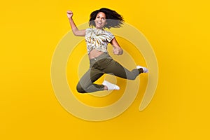 Full size photo of young excited african girl rejoice winner success jump isolated over yellow color background