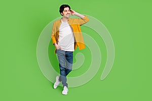 Full size photo of young handsome flirty coquettish guy look copyspace dreaming isolated on green color background