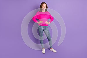 Full size photo of young happy cheerful positive smiling girl wear pink sweater and jeans isolated on violet color