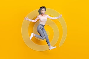 Full size photo of young happy excited funky girl jumping running in iar screaming isolated on yellow color background