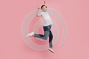 Full size photo of young happy excited smiling positive man in jumping isolated on pink color background