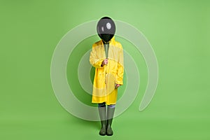 Full size photo of young man anonym close face air balloon party decoration wear raincoat isolated over green color
