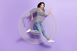 Full size photo of young shocked amazed funky girl jumping playing invisible guitar isolated on violet color background