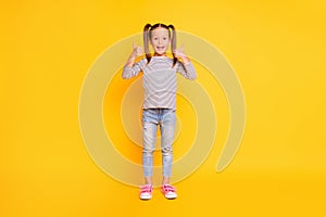 Full size photo of young smiling happy girl kid child showing thumb-up  on yellow color background