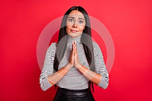 Full size photo of young unhappy upset scared girl asking begging hold hands in prayer isolated on red color background