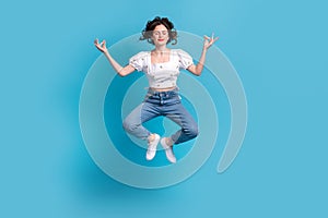 Full size portrait of carefree lovely girl jumping flying closed eyes meditate isolated on blue color background
