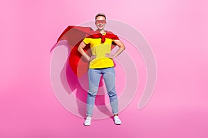 Full size portrait of positive strong super girl put hands waist wear red cape costume empty space isolated on pink