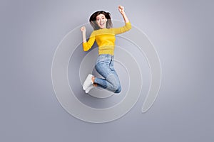 Full size profile photo of optimistic brunette nice lady jump wear yellow sweater jeans sneakers isolated on grey color