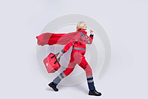 Full size profile side photo of brave serious paramedic old woman walk hold bag wear cape isolated on grey color