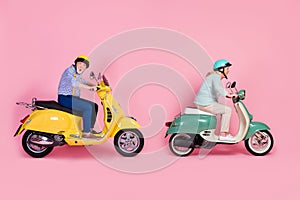 Full size profile side photo of shocked amazed mature couple in helmet white grey hair ride scooter fast isolated on