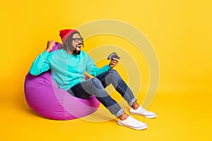 Full size profile side photo of young african man happy positive smile rejoice victory video game isolated over yellow