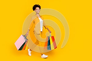 Full size profile side photo of young afro girl go walk shopping store isolated over yellow color background