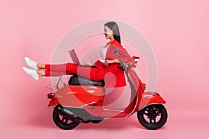 Full size profile side photo of young cheerful lovely businesswoman sit moped working in laptop isolated on pink color