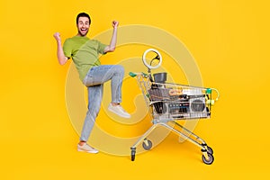 Full size profile side photo of young man celebrate victory lottery swap unused stuff isolated over yellow color