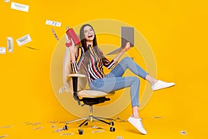 Full size profile side photo of young woman happy positive smile shoot money cash air fly laptop isolated over yellow