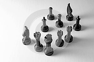 Full sized black marble chess pieces on solid background