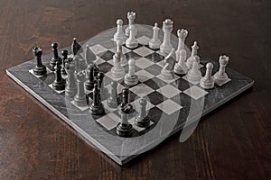 Full sized black and white marble chess board and pieces