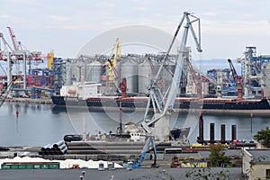 Full-slewing switch crane of gray color against the background of the cargo berth.